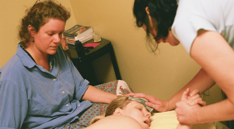 doula and midwife supporting mom in labor
