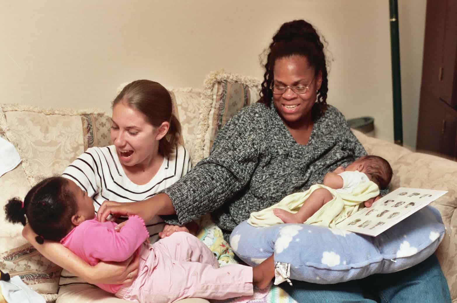 Postpartum doula provides breastfeeding and sibling support